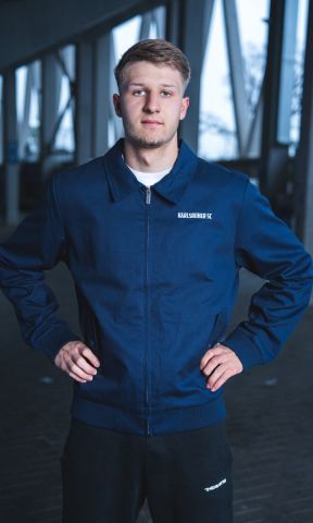 KSC Jacke, Oberstoff: 100 % Baumwolle, Futter, 100 % Polyester, Klassischer Harrington-Stil mit modernem Schnitt, „Karlsruher SC“-Schriftzug auf der Brust, Durchgehender Reißverschluss mit Stehkragen, weiches Innenfutter, Elastische Bündchen an Ärmeln