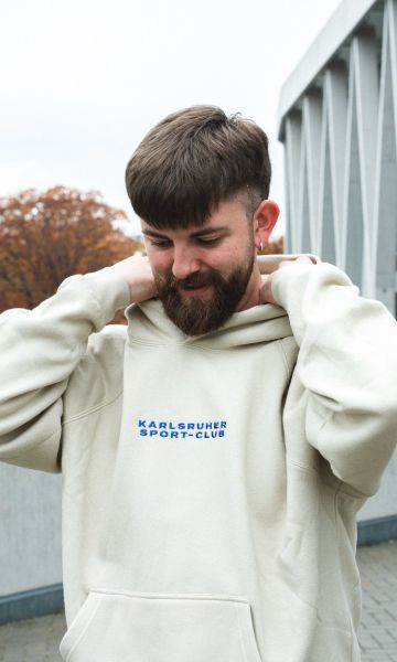 KSC Hoodie, Cremefarben, 60 % Baumwolle, 40 % Polyester, gestickter Schriftzug Karlsruher Sport-Club, Backprint mit Nacktem Mann und dynamischem Karlsruhe-Schriftzug, Kängurutasche, Kapuze 